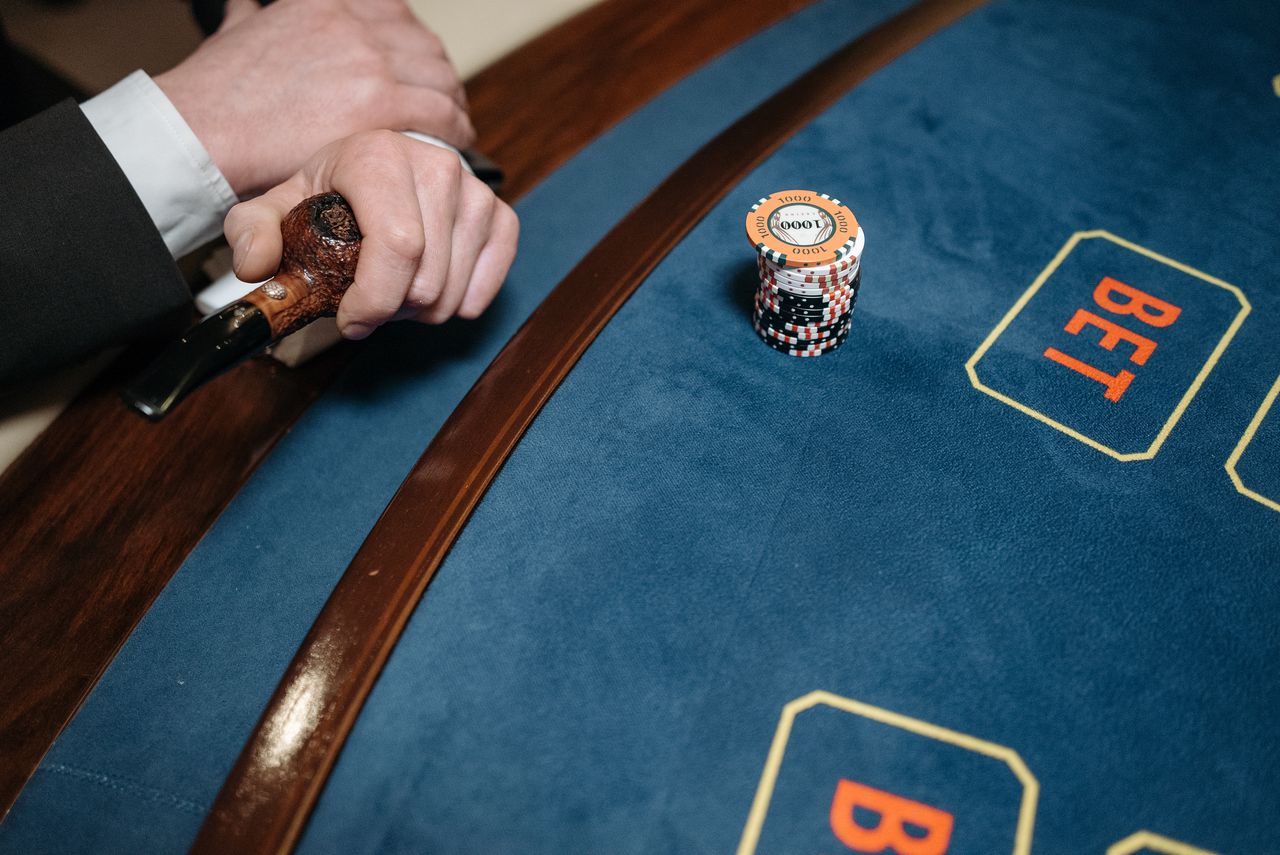Services Detailed view of a casino gaming table with poker chips and a wooden pipe on the side.