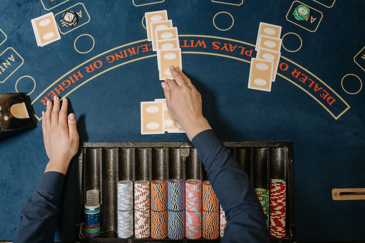 Services Dealer hands distributing cards at a casino blackjack table with chips in view.