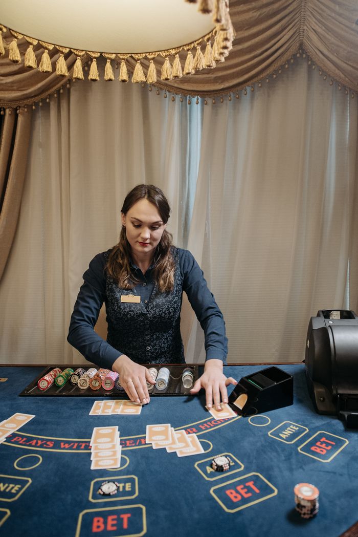The Art of Drawing Readers In: Your attractive post title goes here A female dealer managing chips and cards on a casino gaming table indoors.